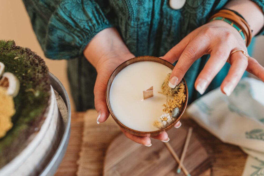 Inside Kristy's craft space making candles with botanicals and wood wicks.